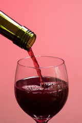 Girando o vinho na taça com o fundo rosa