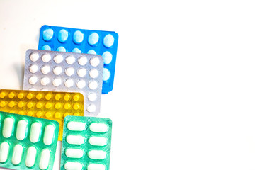 Colorful Many pills and tablets isolated on white background, pharmaceuticals antibiotic drug capsule pills in package.
