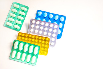 Colorful Many pills and tablets isolated on white background, pharmaceuticals antibiotic drug capsule pills in package.
