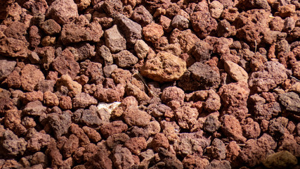 Mineral Background: Rough brown rocks and stones with different shapes scattered everywhere.