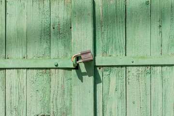 An old rusty lock on an old wooden gate.