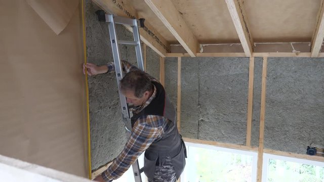 Senior handyman working on wall isolation