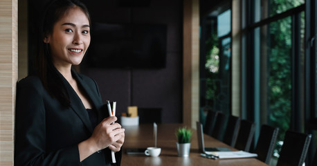 Portrait of asian businesswoman standing at meeting room in office