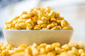 Breakfast food Corn Pops cereal in white ceramic bowl on kitchen counter top
