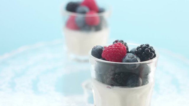 Transparent Glasses Full of Yogurt, Panna Cotta, White Vanilla Mousse Decorated with Berries 
