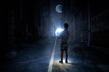 Boy holding moon at night