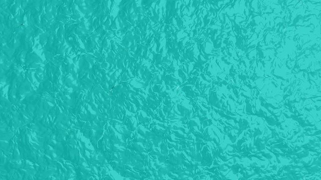 Video animation, natural background with rippled turquoise water surface. Top view of water with very small waves on it surface from soft breeze. Nature, animater backdrop with sea, ocean.