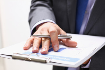 Male hand holding silver pen