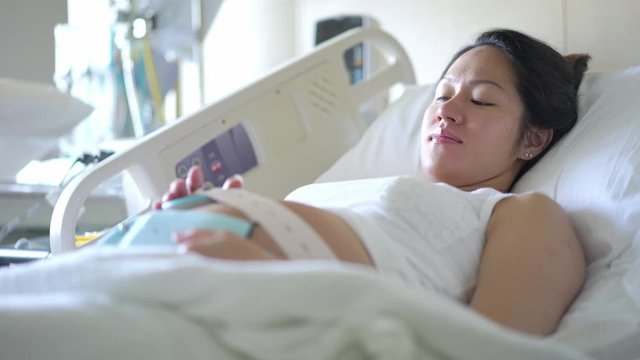 Asian chinese pregnant woman lying on the hospital bed