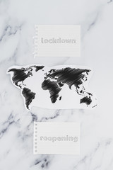 going back to normal after the global pandemic, lockdown versus reopening signs next to world map