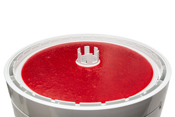 Homemade strawberry pastille. A dryer for making a delicious and healthy dessert isolated on white background.