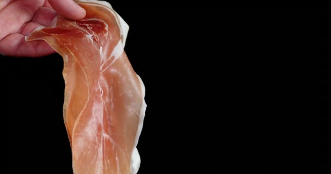 Man's hand holds a meat antipasto.