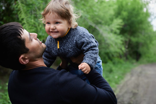 A Cute Little Blonde Haired, Blue Eyed Boy Plays With His Dad In An Outdoor Field, Fathers Day