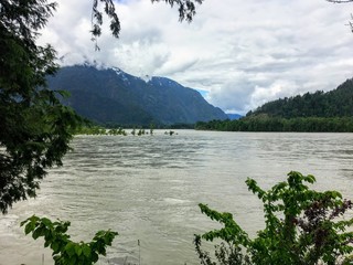 A view of the wide Fraser river with the mountains in the background, outside Hope, British Columbia, Canada