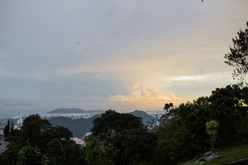 Beautiful view from the mountain to the city below and to the sea with islands. Fascinating sunset view. Sunset color of the sky and beautiful clouds.