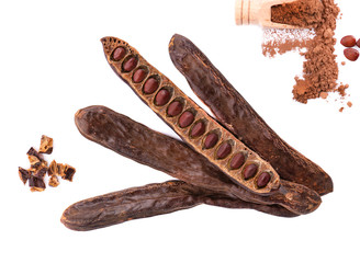 Ripe carob pods and bean isolated on white background. Top view.
