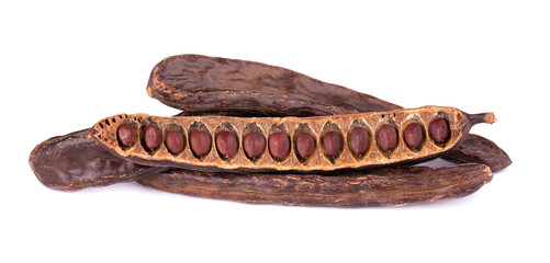 Ripe carob pods and bean isolated on white background.