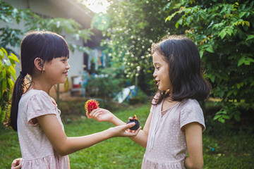 Two girls change her fruit in the garden theme