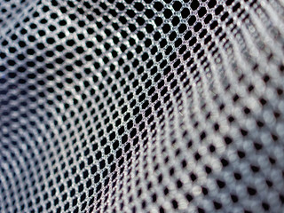 Black polyester mesh with large holes for free air circulation. Material for sportswear, animal carriers and others. Macro image.