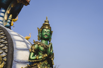 Fototapeta na wymiar Grüne Statue vor dem blauen Tempel (Wat Rong Sua Ten) in Chiang Rai