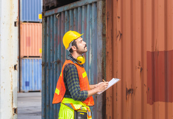 Worker man holding clipboard checklist and checking containers box from cargo