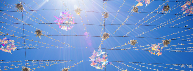 Crystal colorful butterflies with rays of light on a blue sky background wide panoramic