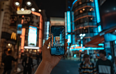 渋谷の街並みをスマートフォンで撮影しようとする様子