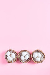 Easter composition on a pink background. decor in the form of nests with eggs. flat lay, space for a text