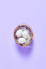spring Easter composition. nest with speckled eggs on a light purple background. the concept of the holiday. simple flat layout