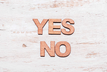 Words yes no in wooden letters.