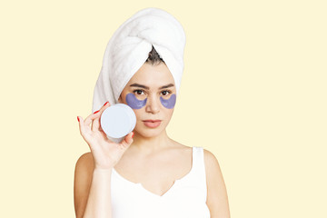 patches, a girl makes a face mask, a bank with cosmetics in her hand