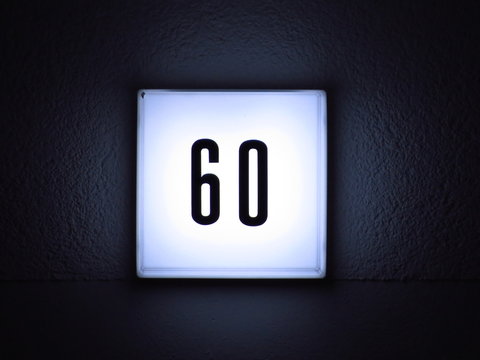 Close-up Of Illuminated House Number On Wall