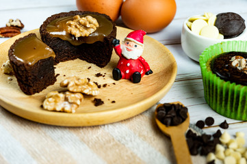 Chocolate Brownie Cake in Paper Cups Decorated with components for making cakes placed on wooden floors