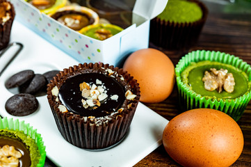 Chocolate Brownie Cake in Paper Cups Decorated with components for making cakes placed on wooden floors