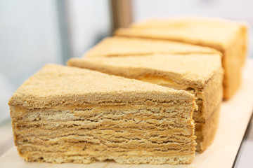 Puff pastry cakes on a cafe window. Cakes sliced into pieces of a triangular shape.