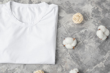 Flat lay Layout for design, White mockup t-shirt for placing fonts, logos and product advertising. With cotton flowers