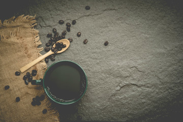 black coffee in the dark green coffee cup above brown hemp sack sheet