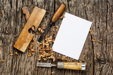 carpenter tools on dark rustic table with blank paper.