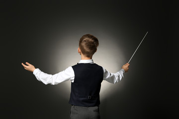 Little conductor on dark background - obrazy, fototapety, plakaty