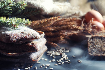 Fresh loaves of bread with wheat and gluten on a black table. Bakery and grocery concept. Fresh, healthy sorts of rye and white loaves food closeup. Fresh homemade bread with cereals.