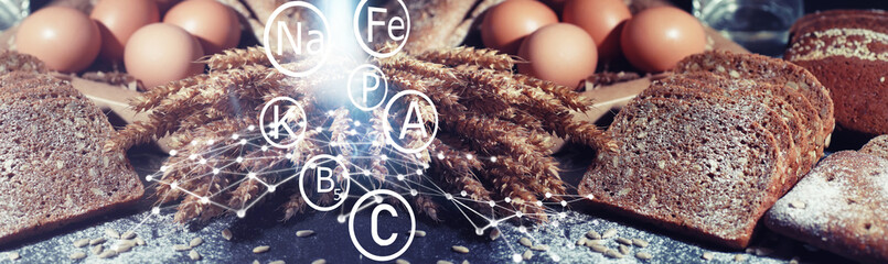 Fresh loaves of bread with wheat and gluten on a black table. Bakery and grocery concept. Fresh, healthy sorts of rye and white loaves food closeup. Fresh homemade bread with cereals.