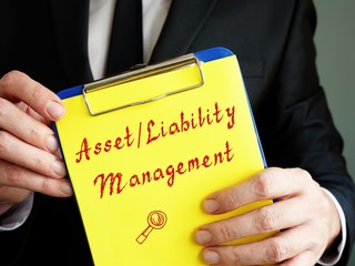 Business concept meaning Examples of Asset/Liability Management with sign on the piece of paper.