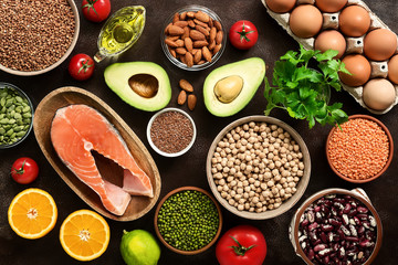 Healthy eating ingredients: fruits, vegetables, legumes, fish, eggs, seeds. The concept of a balanced diet food. Top view, flat lay.