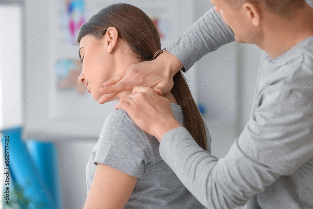 Poster Massage therapist working with female patient in medical center