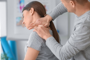 Massage therapist working with female patient in medical center