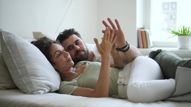 pretty couple in bed talking and touching hands relaxed Spbd. girlfriend and boyfriend in hipster apartment. concept serenity, romance, romance. married wife and husband soulmates