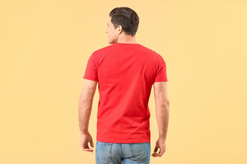 Man in stylish t-shirt on color background