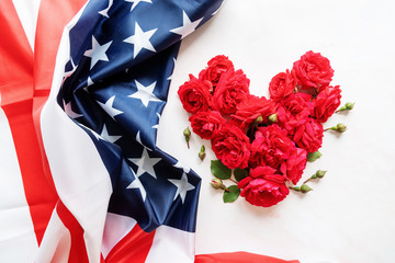 Heart shape of red roses with the USA flag top view flat lay