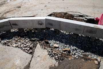 Setting road border before laying asphalt. Reconstruction of the sidewalk and replacement of old curbs. Road infrastructure repair