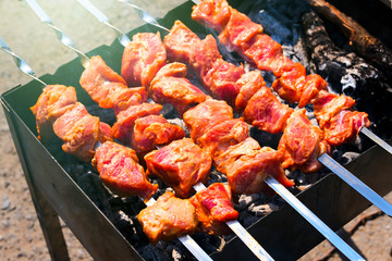 Raw skewers on put on the barbecue and ready to cook. Sale.